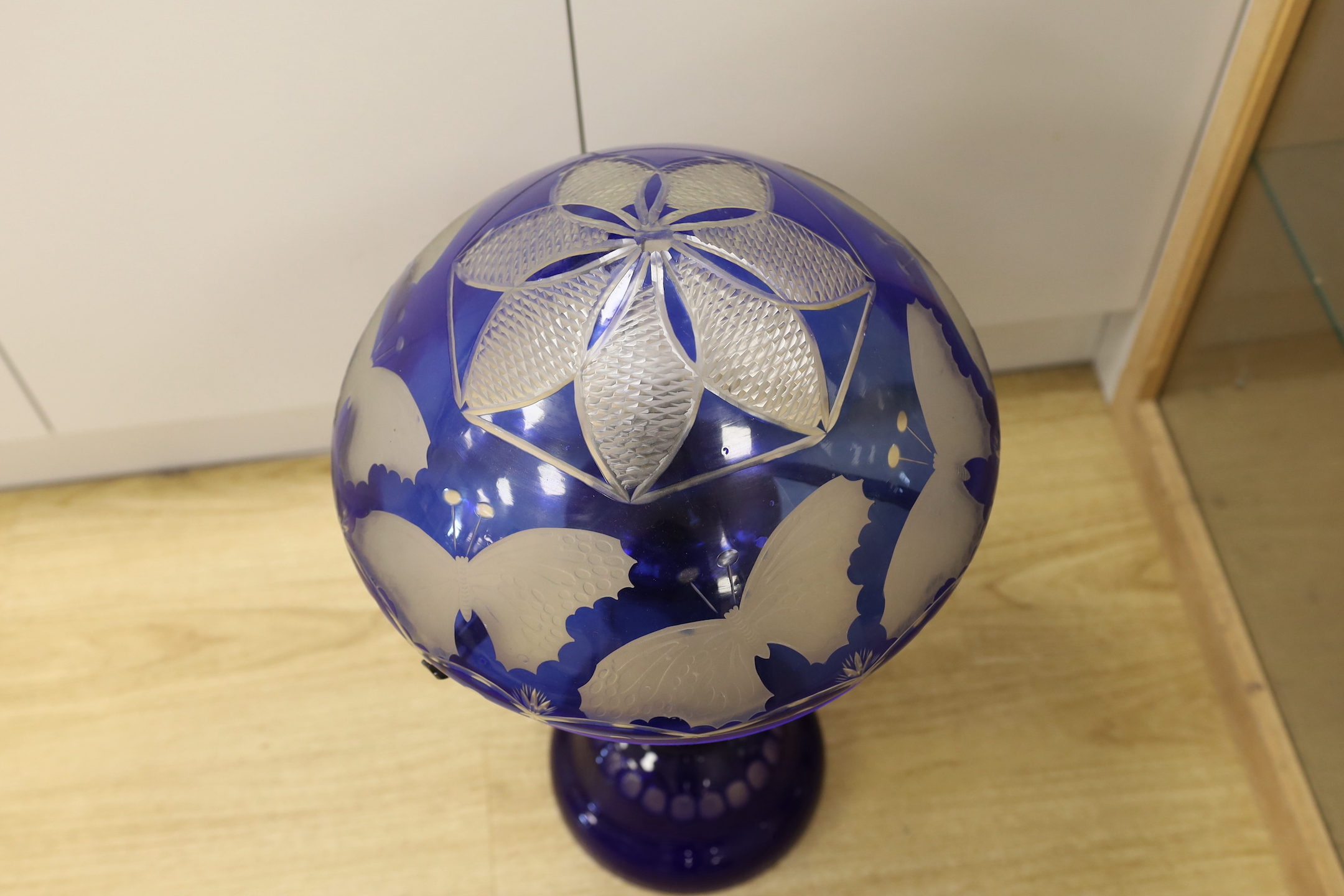 A blue flashed glass mushroom shaped table lamp, with butterfly engraving, 70cm high